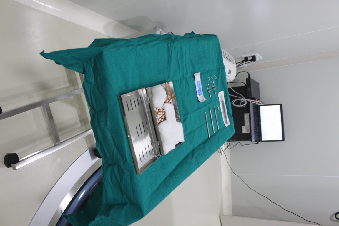 Sterile green-draped surgical instrument tray prepared inside an Insight Institute operation theatre, with stainless cassettes and forceps laid out
